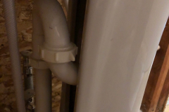 An outdated S-trap under the bathroom sink