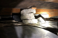 An improper and partially displaced support in a crawl space